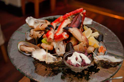 A beautifully arranged seafood platter featuring crab, shrimp, and clams on decorative plates.