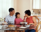 A family enjoying a delicious, home-cooked Indian meal around a dining table, highlighting warmth and togetherness.