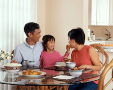 Happy family discussing finances around a kitchen table.