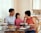 A cheerful family enjoying a meal together at a dining table filled with fresh food.