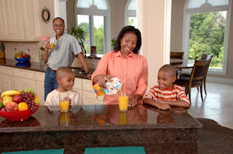 man, woman, and two boys inside kitchen