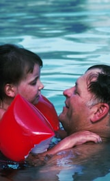 man with toddler girl in swimming pool