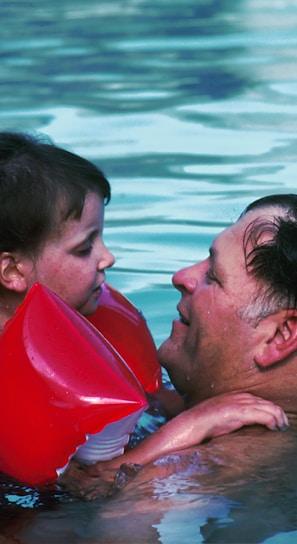 man with toddler girl in swimming pool