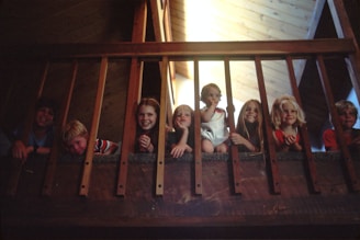 children peeking through railing