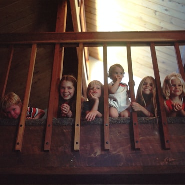 children peeking through railing