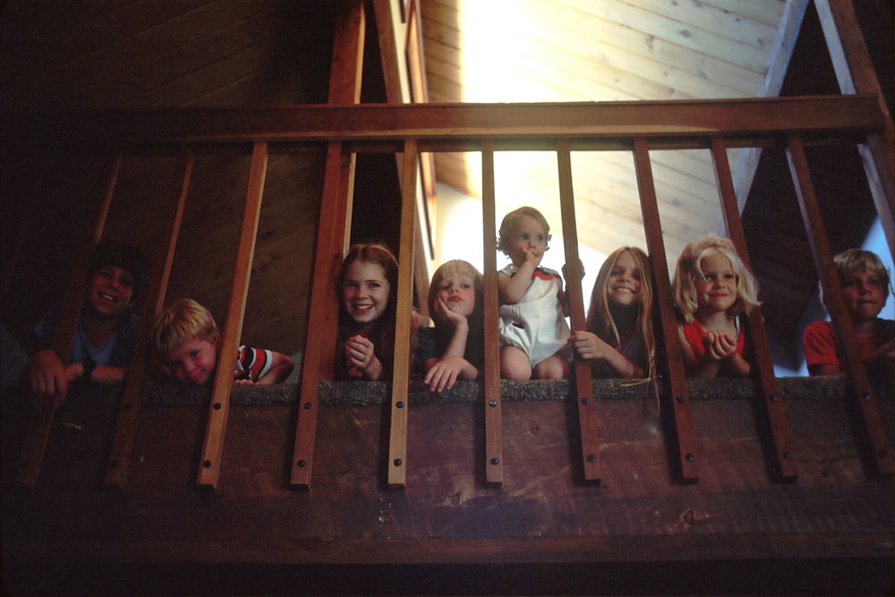 children peeking through railing