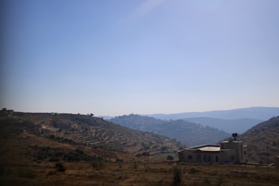 A scenic exterior view of a Texas Hill Country property with blue skies and natural landscaping.