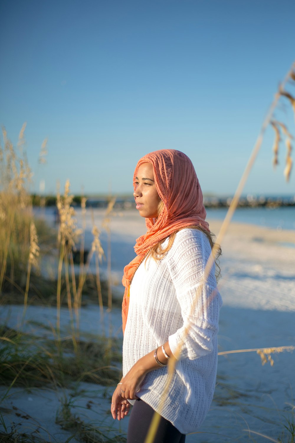 woman wearing white long-sleeved blouse and orange hijab