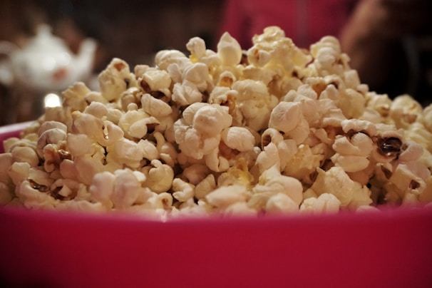 Bright yellow hipopopamus popcorn with a tangy cheese coating in a colorful bowl