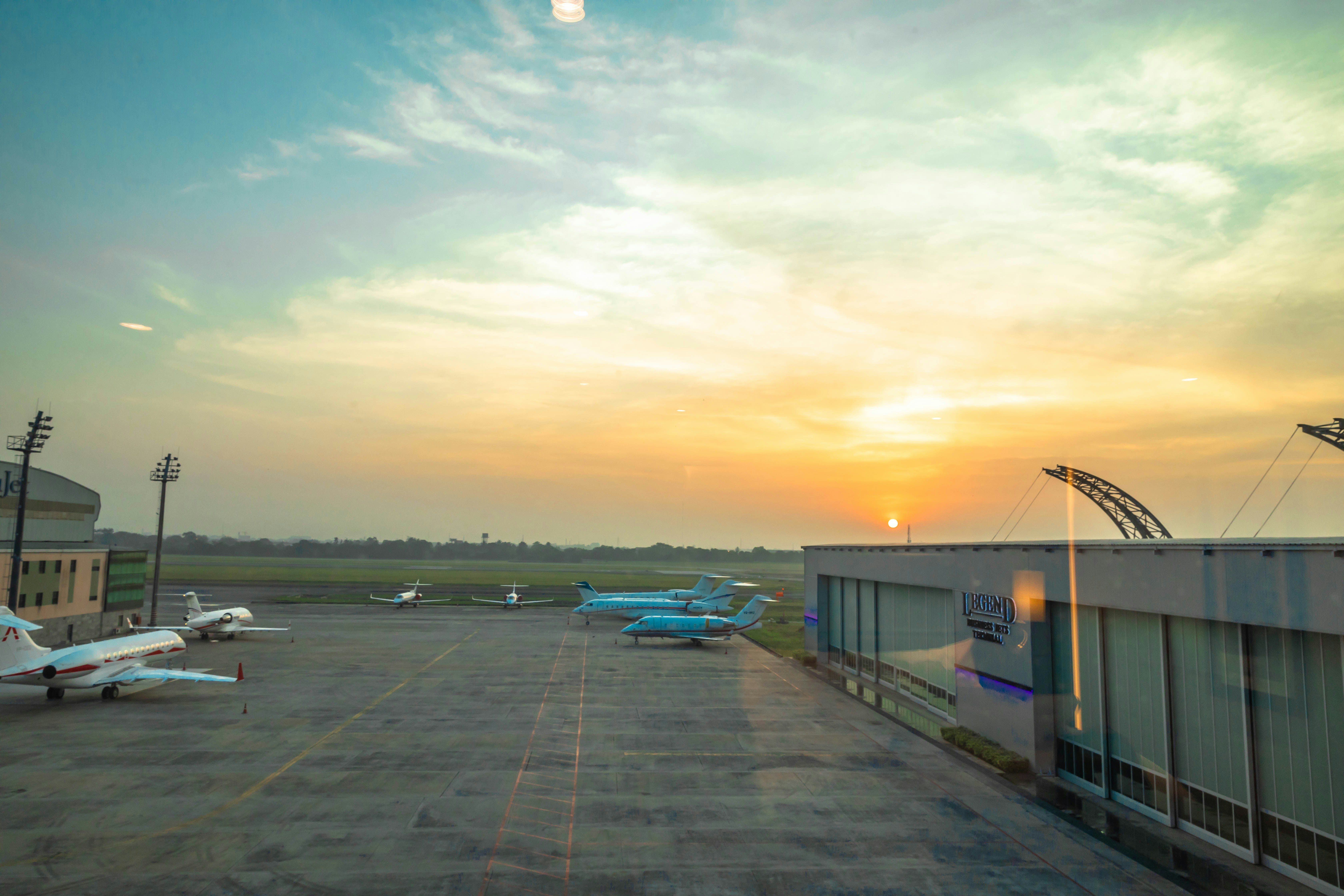 Modern airport terminal at sunrise with planes on the tarmac ready for departure