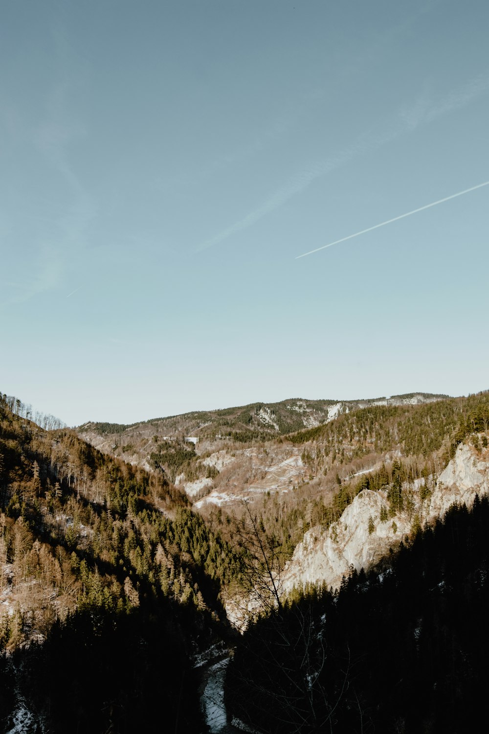 aerial photography of field and mountain covered with snow under blue and white sky