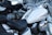 Several motorcycles are parked closely together. The focus is on a white motorcycle with chrome accents including the mirrors, engine parts, and instrument panel on the fuel tank. The seats are black and leather, and the motorcycles appear to be in good condition.