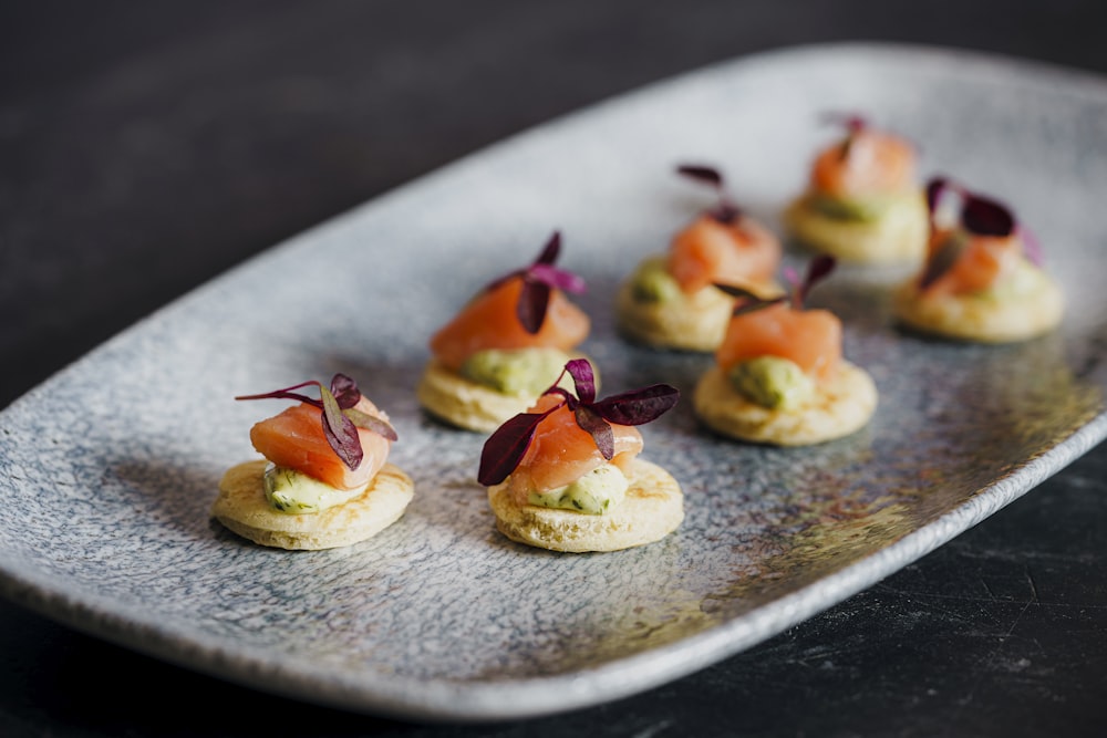 Los pequeños aperitivos están dispuestos en un plato de plata.