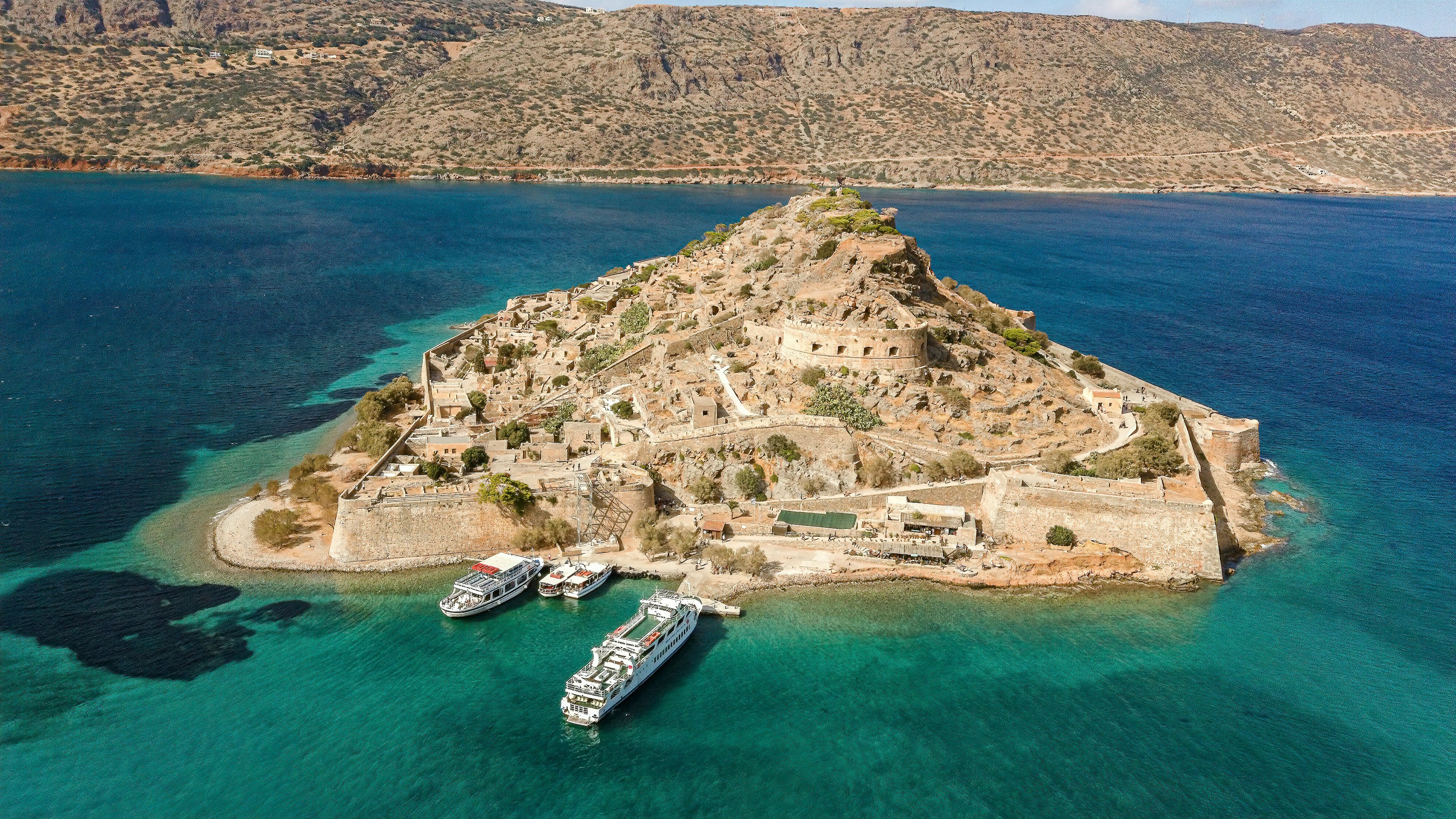 cruise ship and boats docked beside isle with buildings