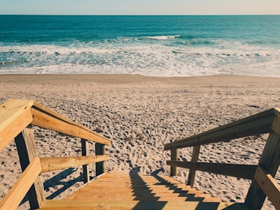 brown wooden stairs on sand seashore during day florida teams background