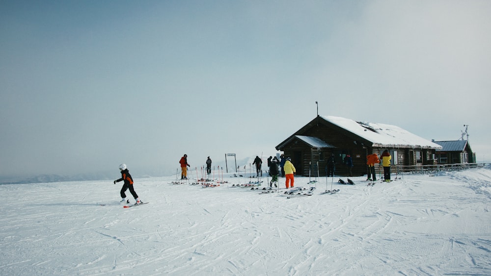 people on snowfield near house