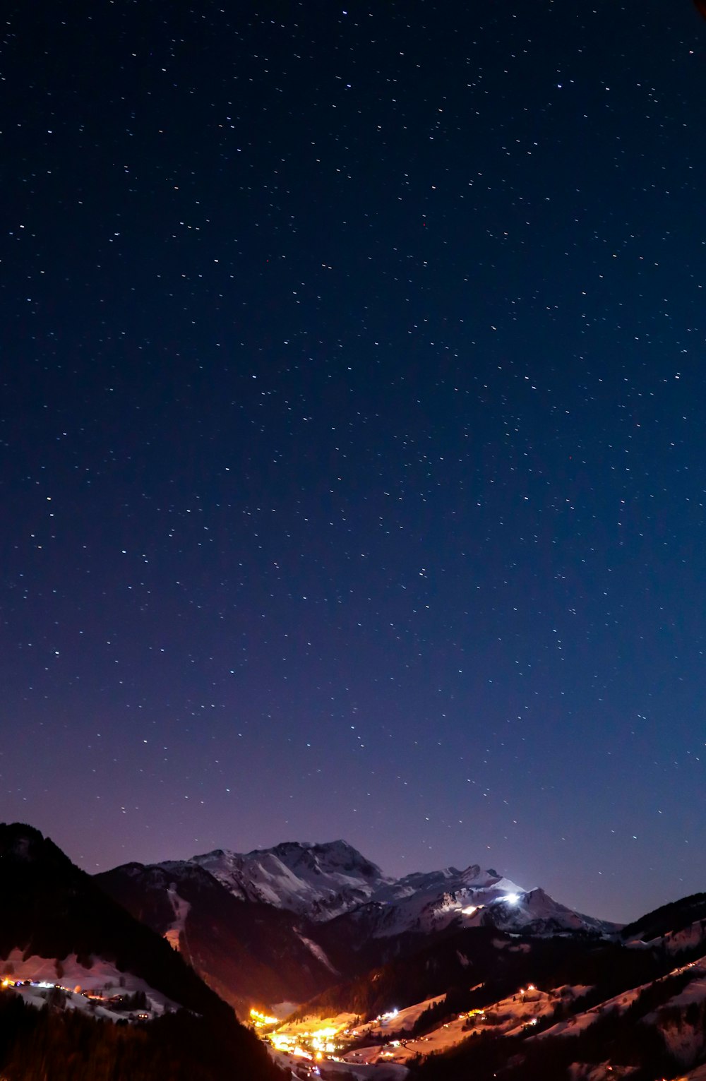 aerial photography of houses on field viewing mountain during night time