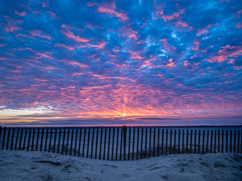 white sands on beach under blue and orange sky