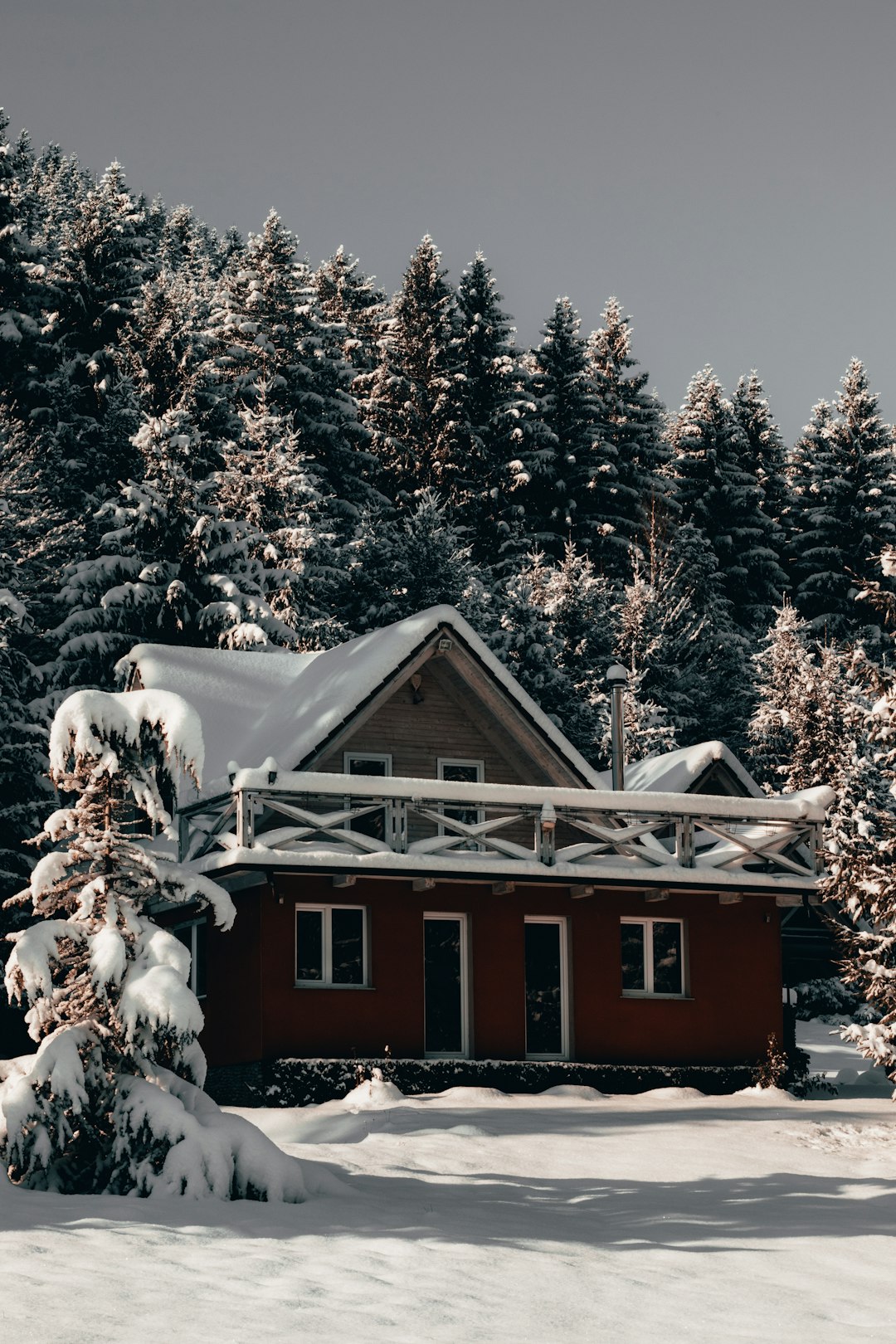 snow covered red house near trees during day