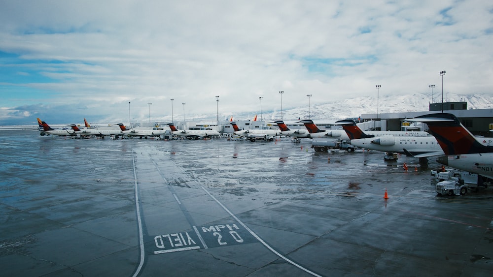 white airplanes on railway under white and blue sky