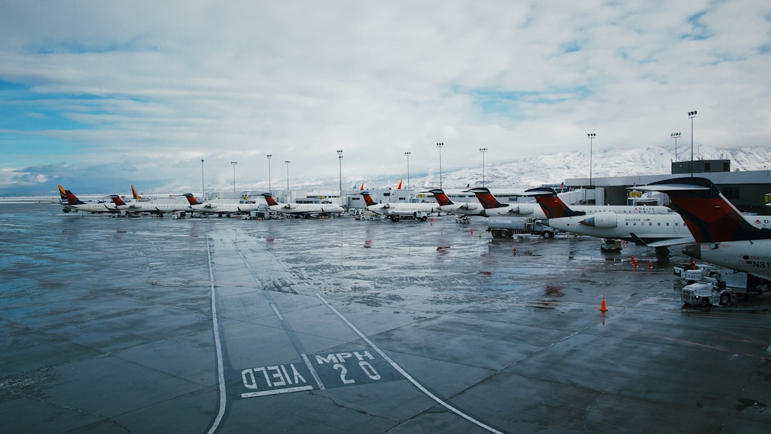 white airplanes on railway under white and blue sky,