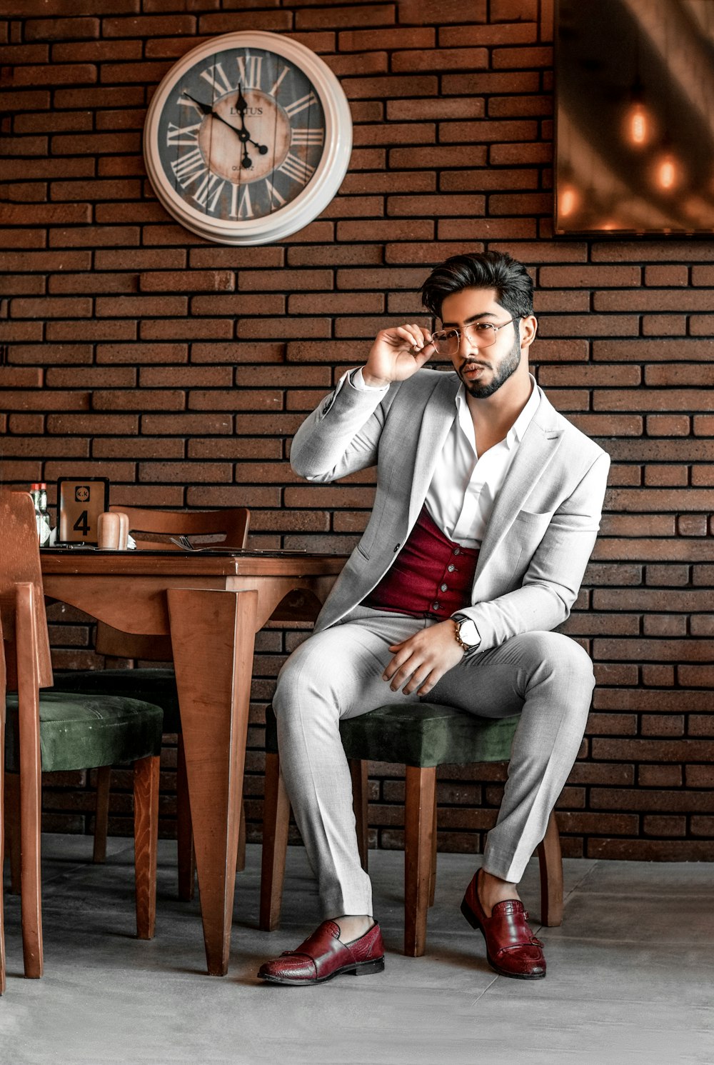 woman in gray blazer and gray pants sitting on brown chair