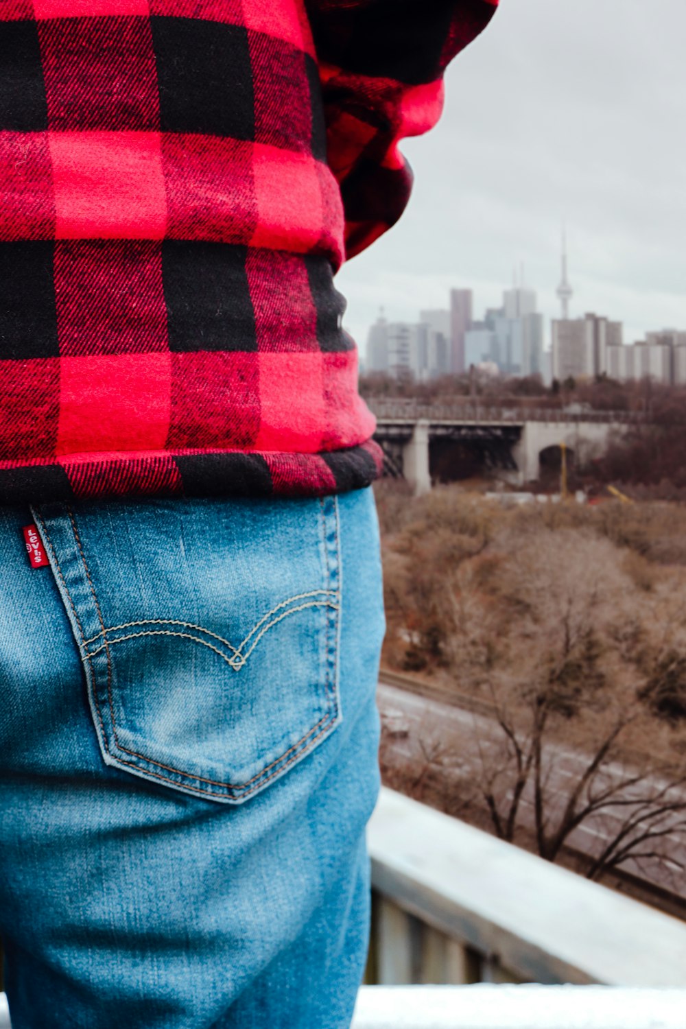 unknown person in red and black top and blue denim bottoms