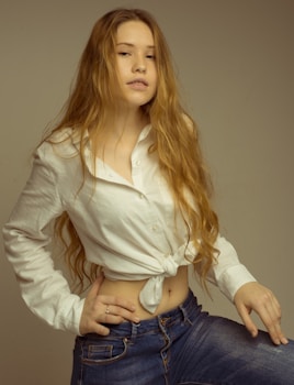femme cheveux long en haut court blanc à manches longues et bas en jean bleu