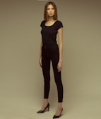 Model wearing a sleek black minimaltees t-shirt paired with casual jeans outdoors.