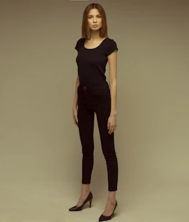 Model confidently walking wearing a body suit with perfect tailoring and subtle compression, against a neutral backdrop