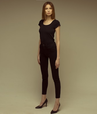Model wearing a sleek black minimaltees t-shirt paired with casual jeans outdoors.