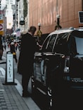 man standing beside vehicle