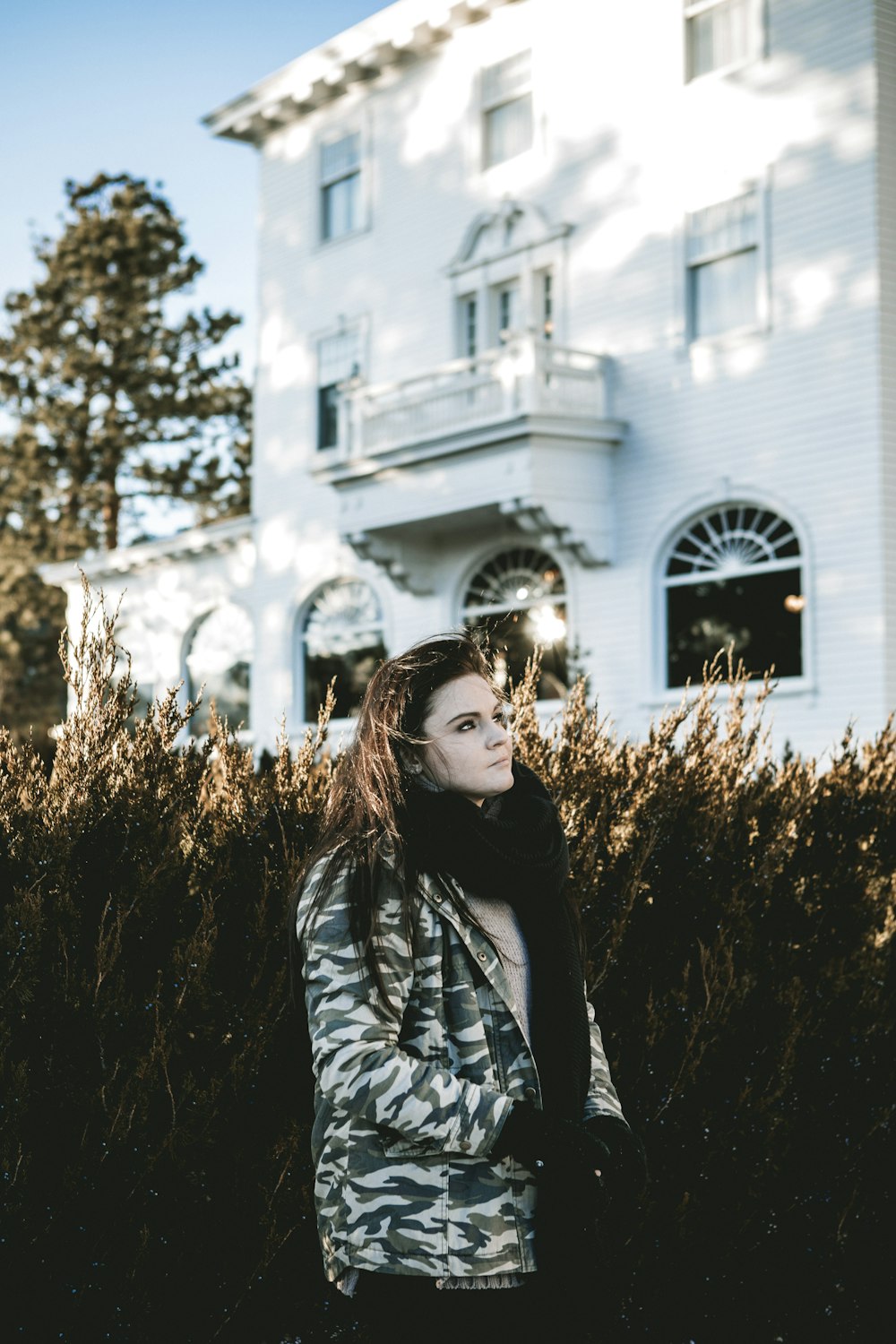 Femme en veste de camouflage grise debout à l’extérieur