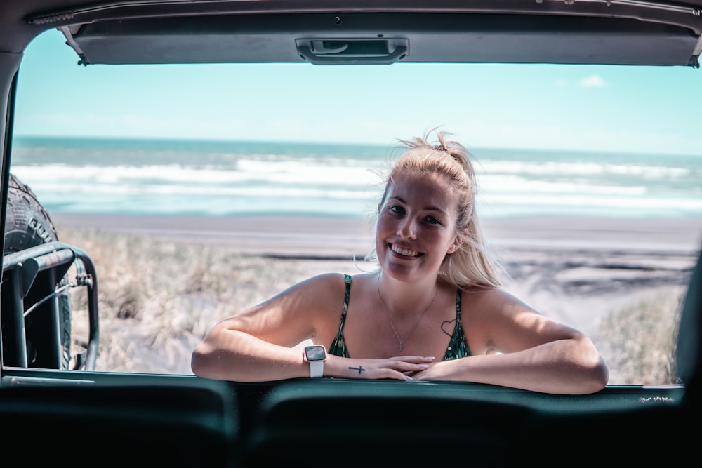 woman leaning behind vehicle