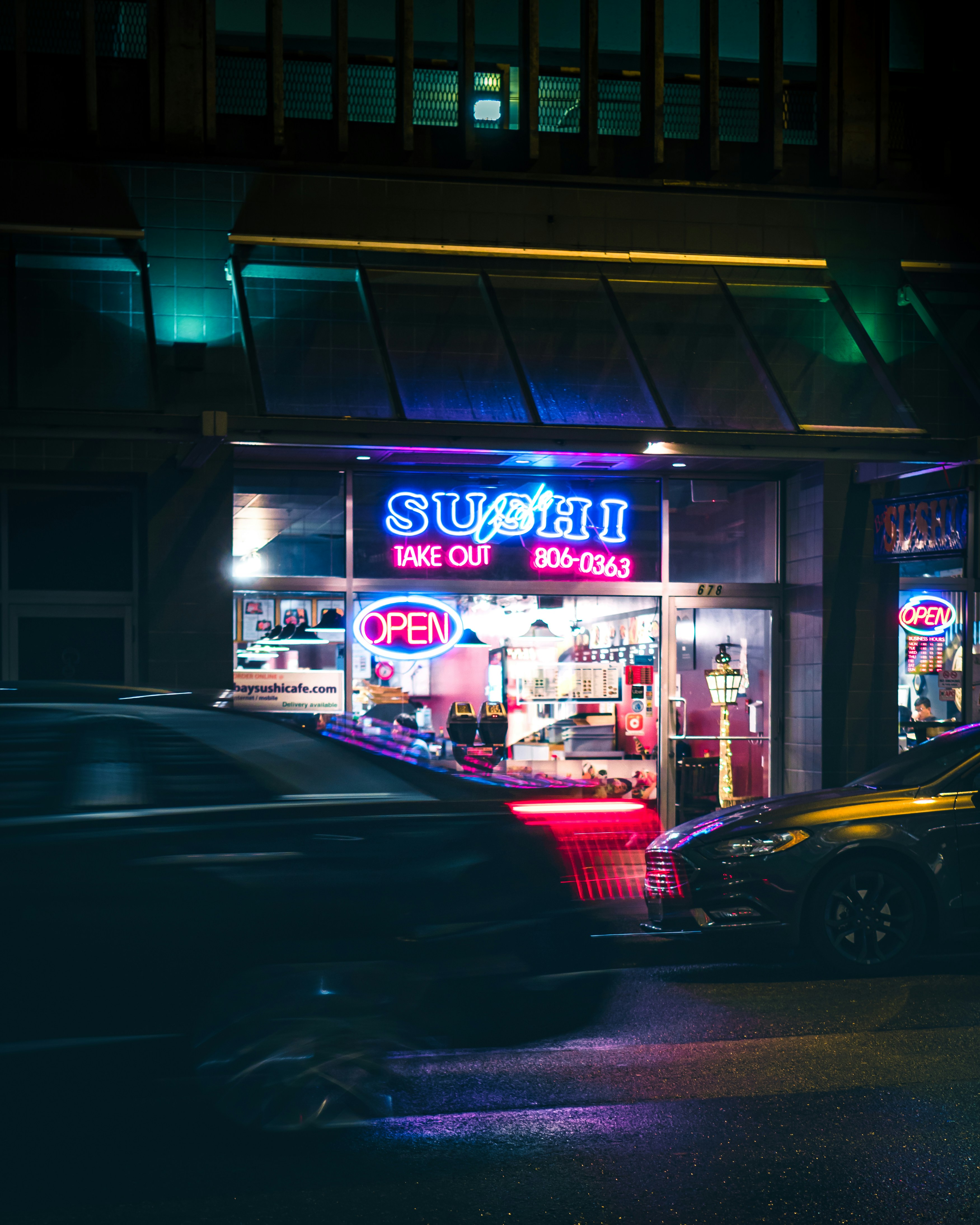 Sebuah mobil diparkir di luar restoran pada malam hari