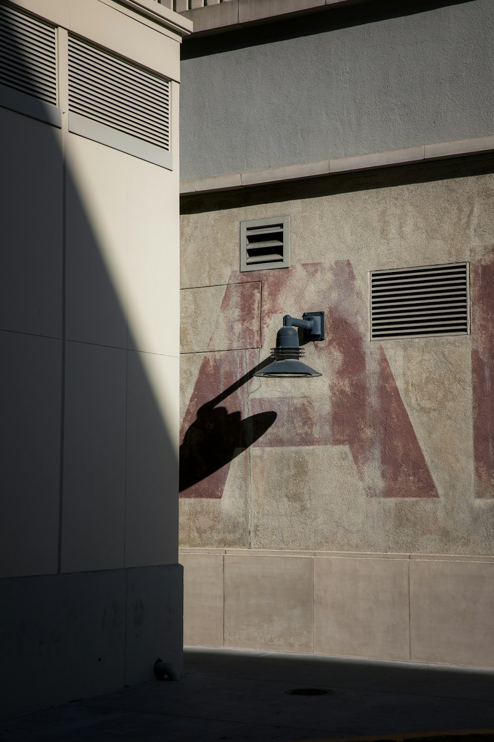 a shadow of a person holding a clock on the side of a building