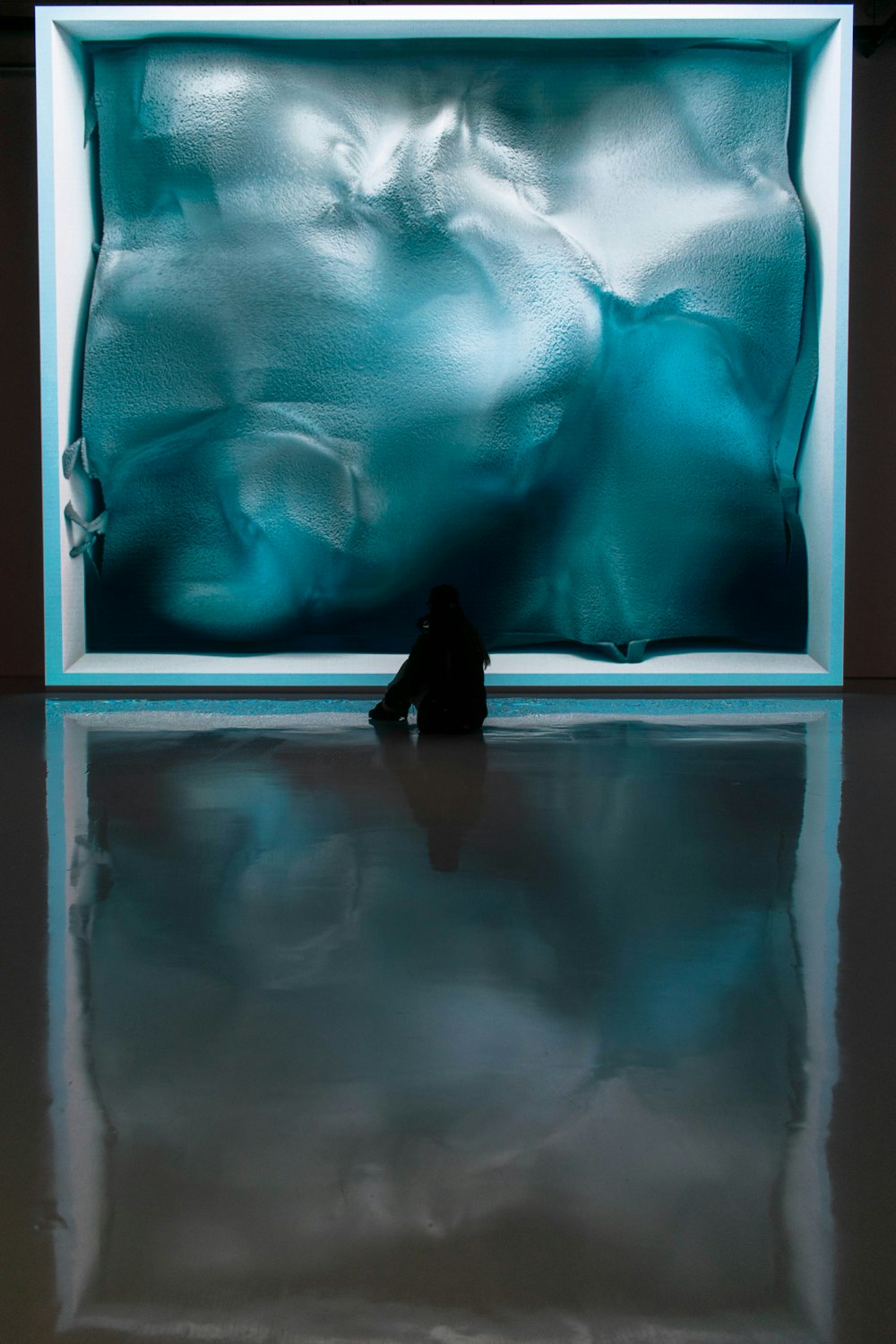 a person sitting in front of a glass window