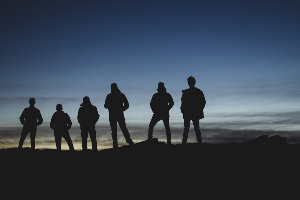 a group of people standing on top of a hill