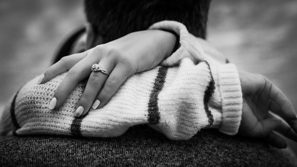 a woman holding a man's arm with a ring on it