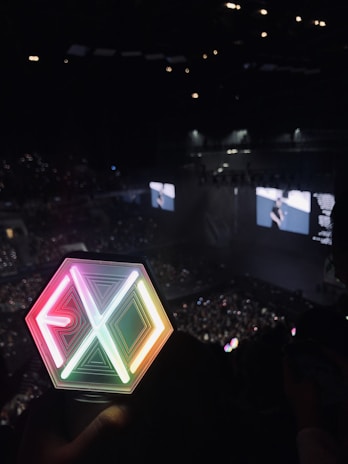 Close-up of a colorful K-pop lightstick glowing in a dark room.
