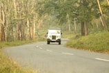 Jeep Willys driving through the misty valley of Cocora with towering wax palms