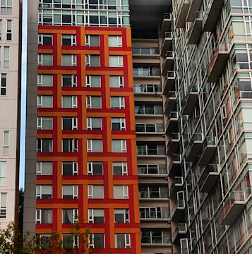 Elegant urban apartment building with bold red accents matching the brand colors.