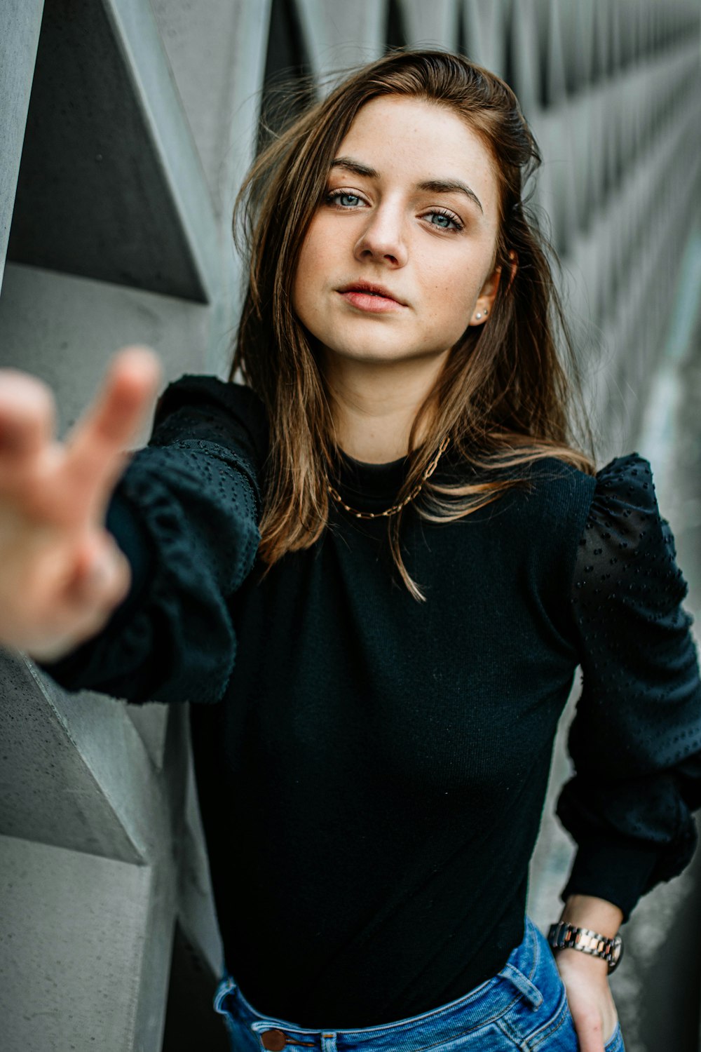 woman in black long-sleeved shirt standing near wall