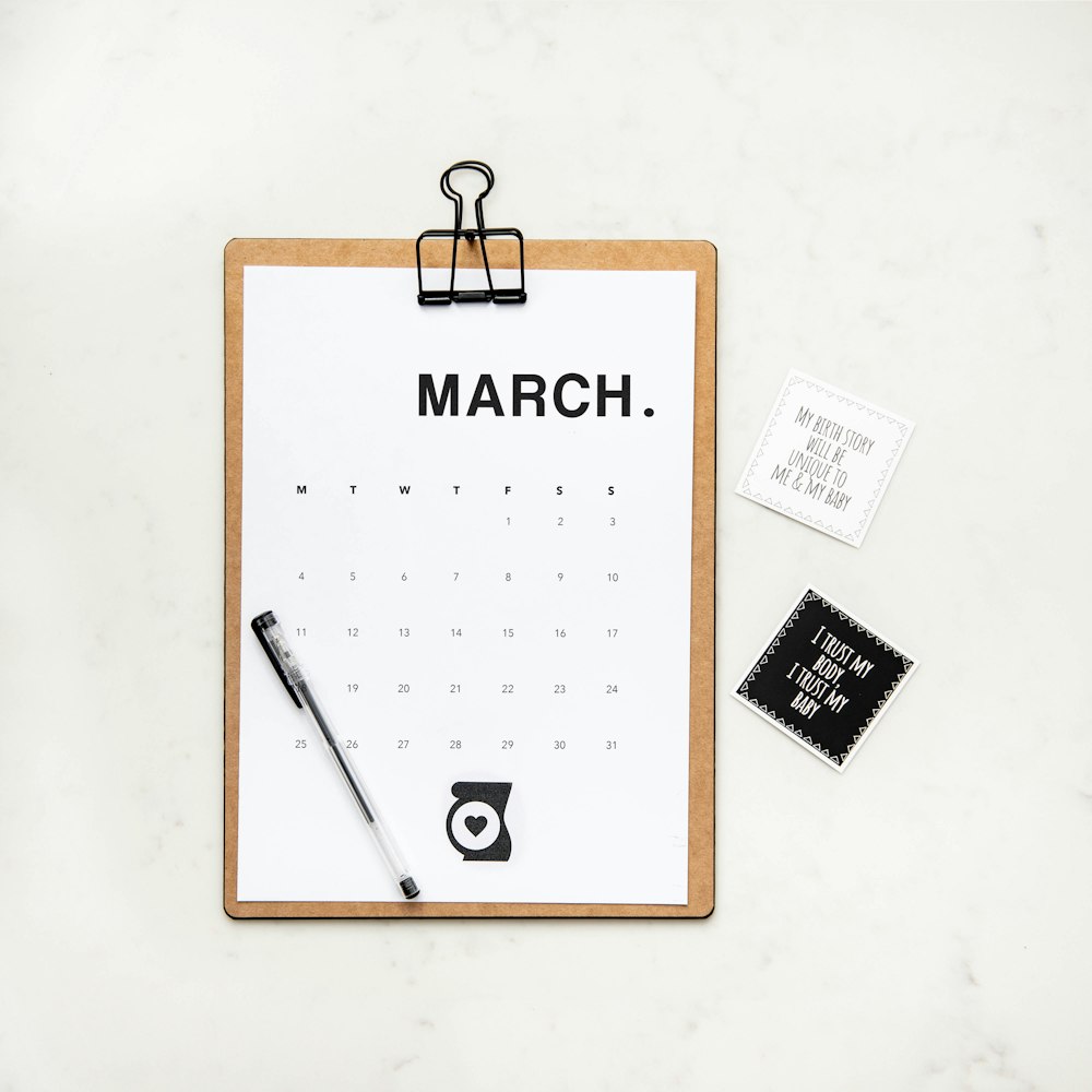 Fotografía minimalista de un calendario con bolígrafo