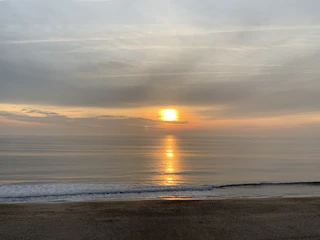 A serene sunrise over a quiet beach, inviting calm and reflection.