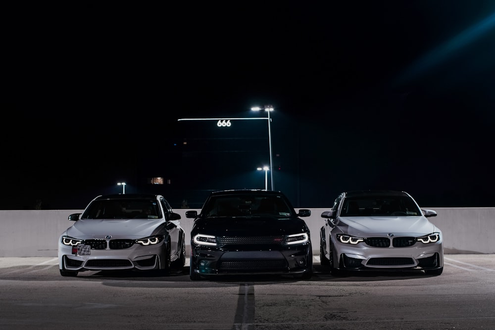 three cars in a parking lot during nighttime