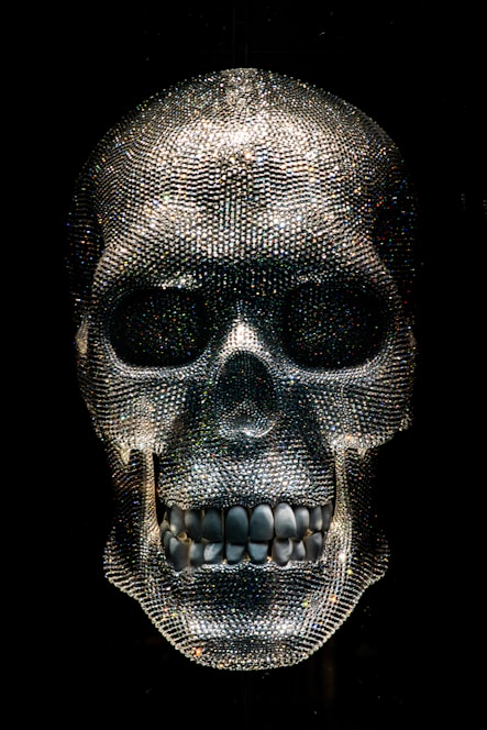 A glowing crystal skull resting on a velvet cushion inside a softly lit museum display.