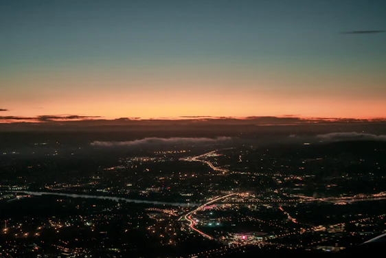 A sweeping vista of Ceikeinu’s five central cities under a twilight sky, each city distinct yet connected by glowing ley lines.