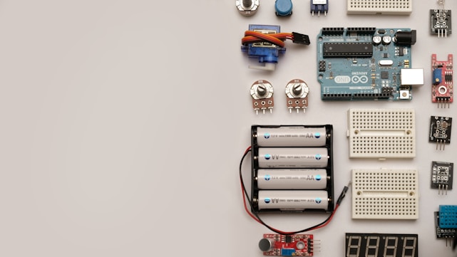A collection of various hardware tools and electronic components arranged neatly on a workbench.