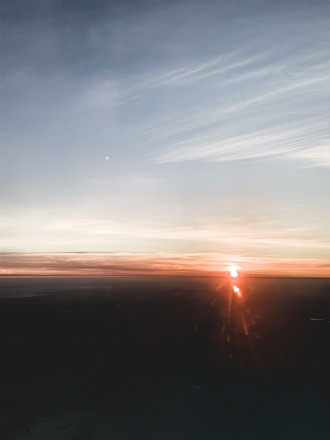 A softly lit sunrise over a calm horizon symbolizing new beginnings and upcoming opportunities.